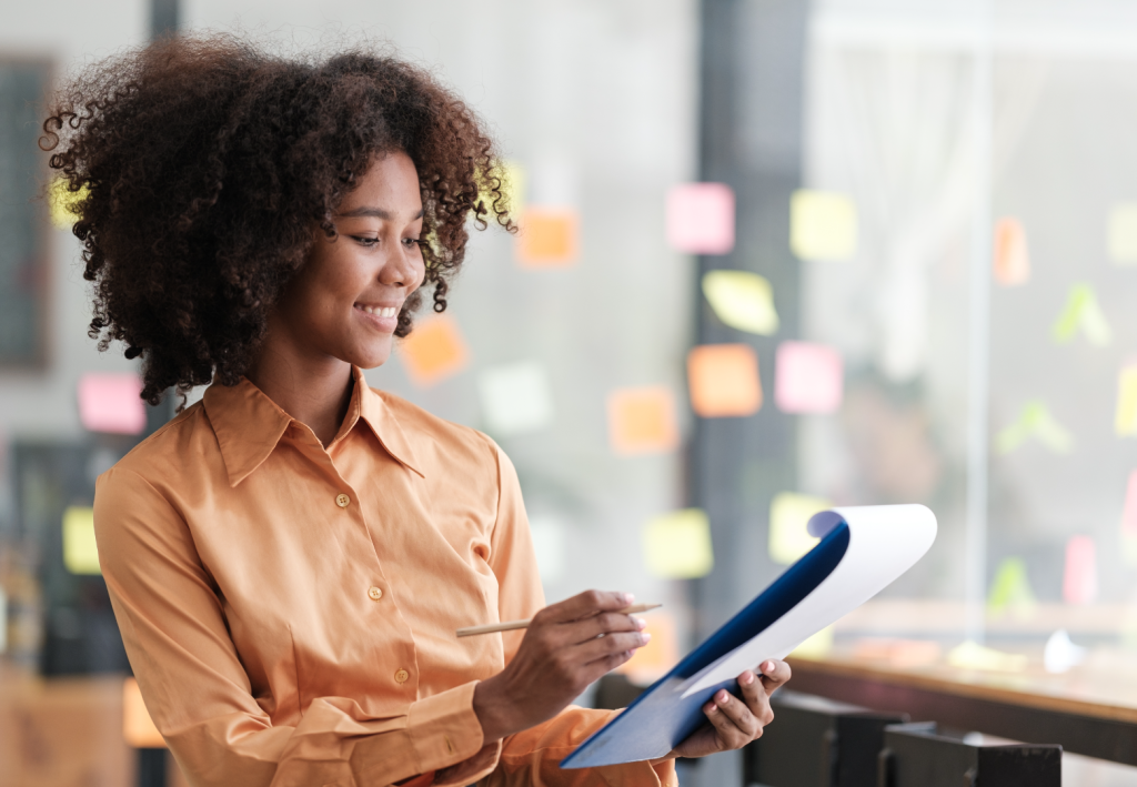 Mulher analisando dados, como o Lead Scoring, o que demonstra a importância da organização e criatividade no trabalho.