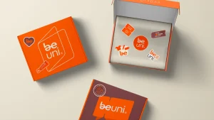 Caixas da beuni apresentando um design vibrante em laranja, com adesivos e elementos de marca evidentes, ideal para promoção e identidade visual.
