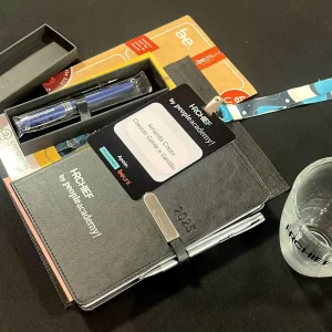 Imagem de um kit de cursos com caderno, caneta e cartão do curso HRCHIEF by peopleacademy! para desenvolvimento pessoal e profissional.