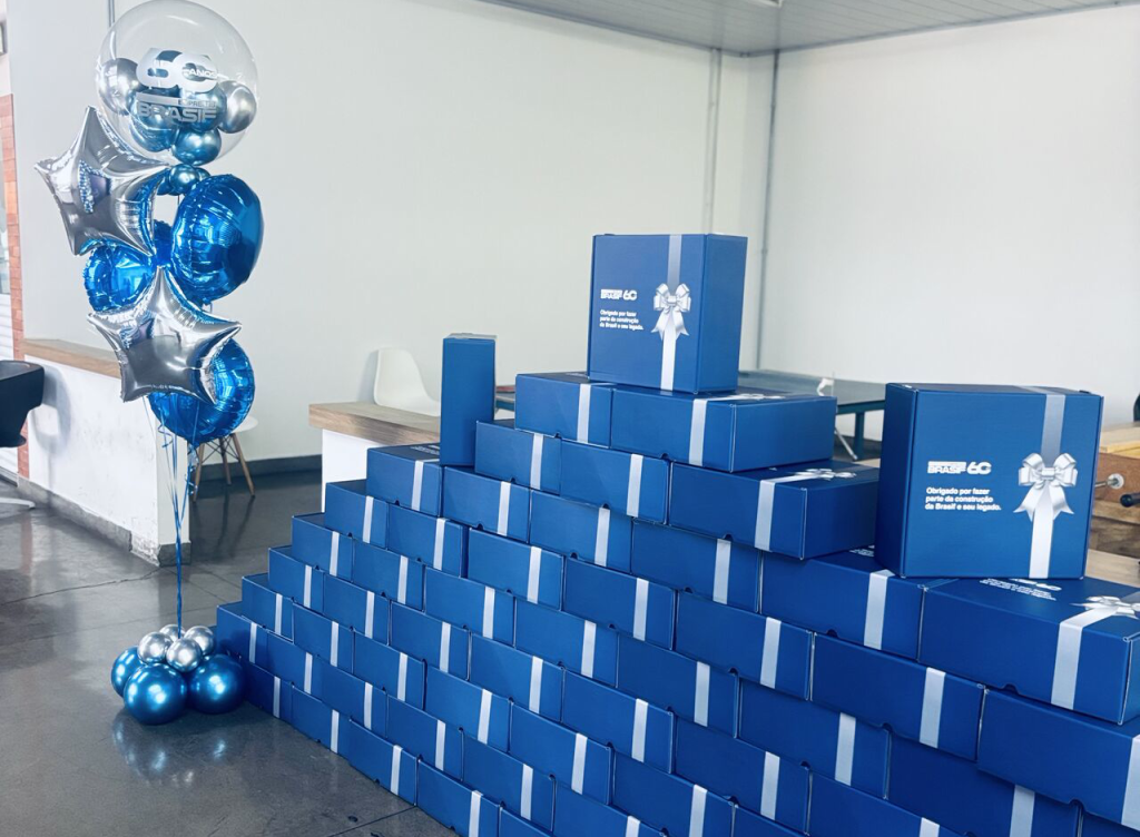 Kits corporativos azuis da Brasif empilhados e prontos para despacho, com decoração de 60 anos